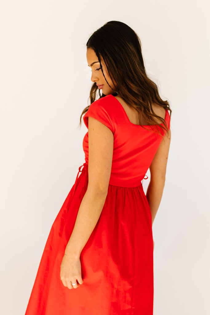 zoco afterglow dress: red short sleeve midi dress with a square neckline and side ties. perfect for date nights, weddings, and family pictures.