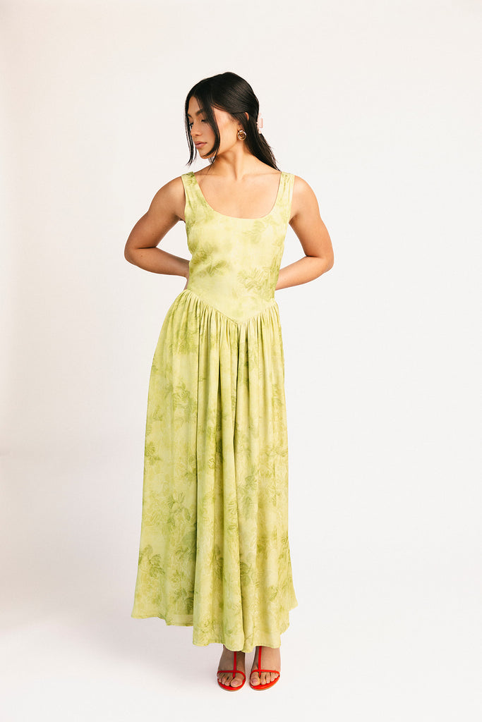 a flowy v-waist green dress with a sleek scoop neckline + subtle floral print. the perfect vintage-inspired maxi dress for weddings, bridal showers, + garden parties.