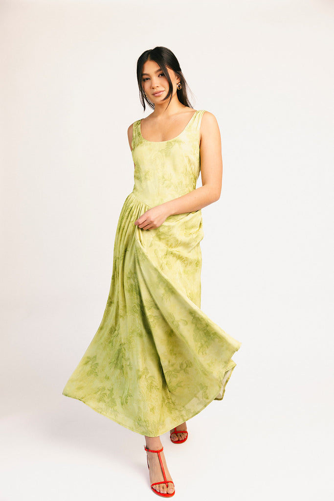a flowy v-waist green dress with a sleek scoop neckline + subtle floral print. the perfect vintage-inspired maxi dress for weddings, bridal showers, + garden parties.