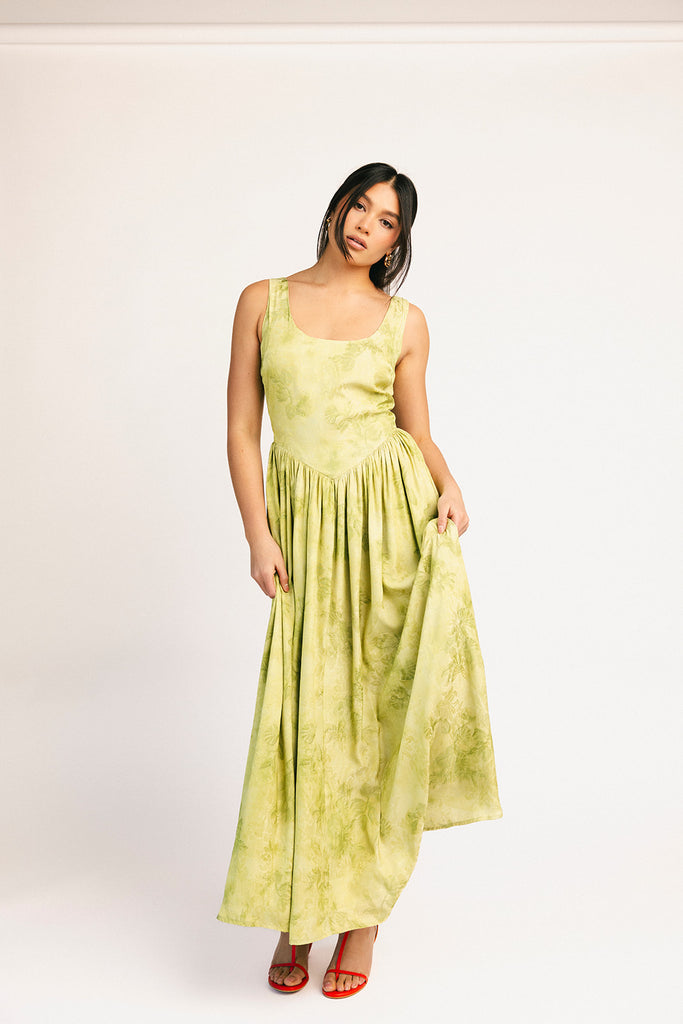 a flowy v-waist green dress with a sleek scoop neckline + subtle floral print. the perfect vintage-inspired maxi dress for weddings, bridal showers, + garden parties.