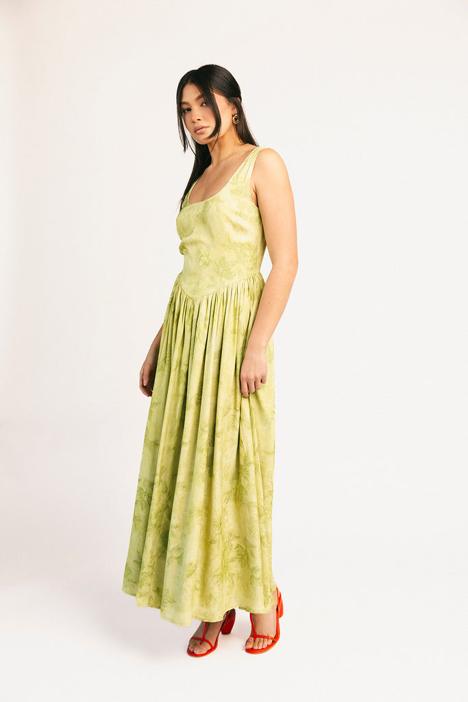 a flowy v-waist green dress with a sleek scoop neckline + subtle floral print. the perfect vintage-inspired maxi dress for weddings, bridal showers, + garden parties.