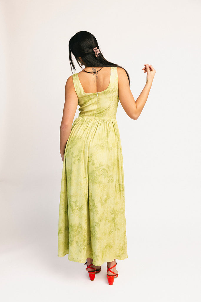 a flowy v-waist green dress with a sleek scoop neckline + subtle floral print. the perfect vintage-inspired maxi dress for weddings, bridal showers, + garden parties.