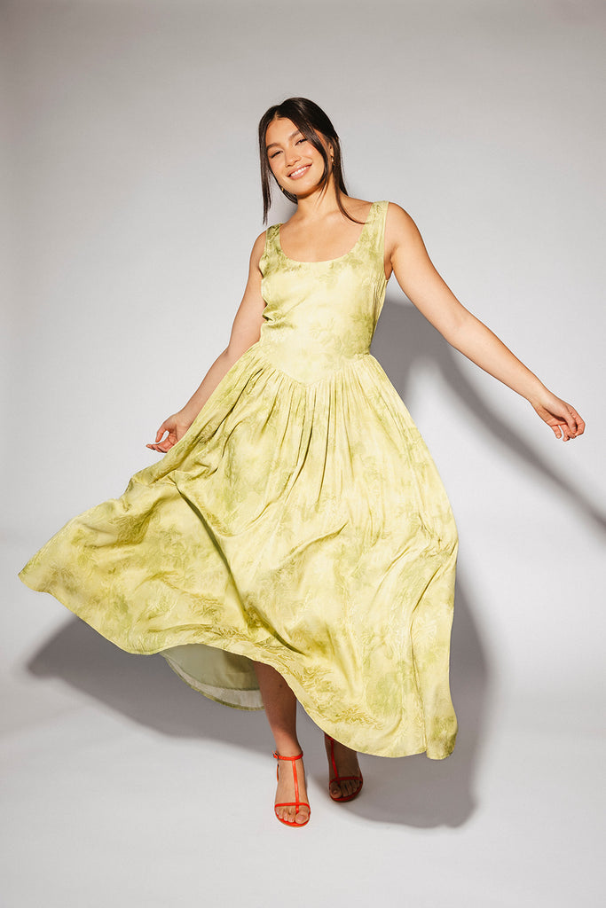 a flowy v-waist green dress with a sleek scoop neckline + subtle floral print. the perfect vintage-inspired maxi dress for weddings, bridal showers, + garden parties.