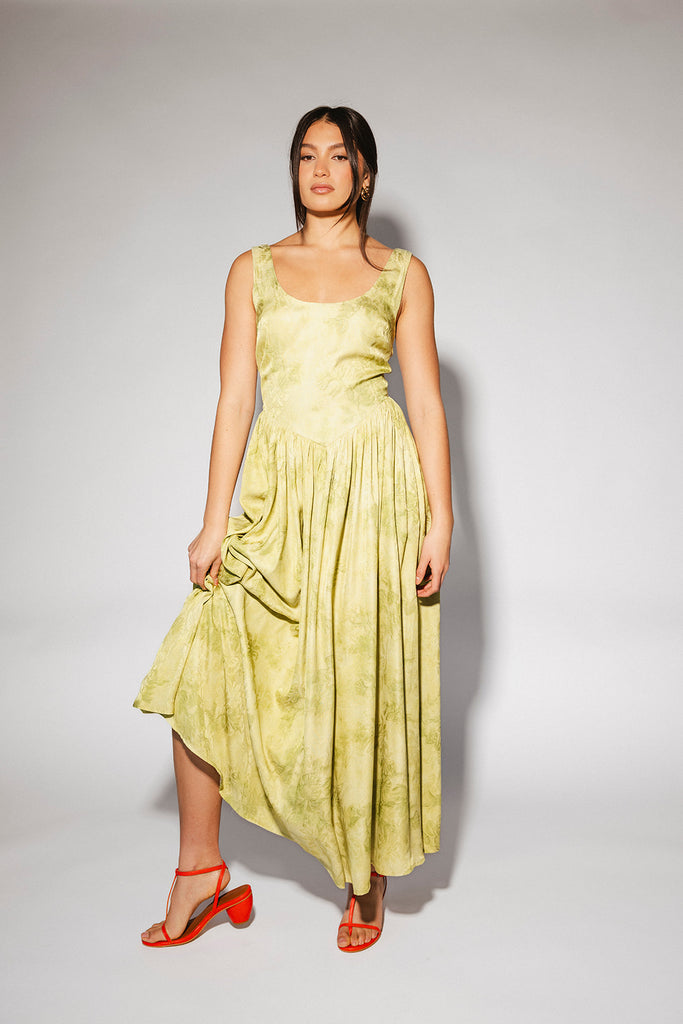 a flowy v-waist green dress with a sleek scoop neckline + subtle floral print. the perfect vintage-inspired maxi dress for weddings, bridal showers, + garden parties.