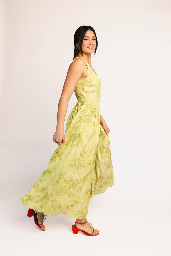 a flowy v-waist green dress with a sleek scoop neckline + subtle floral print. the perfect vintage-inspired maxi dress for weddings, bridal showers, + garden parties.