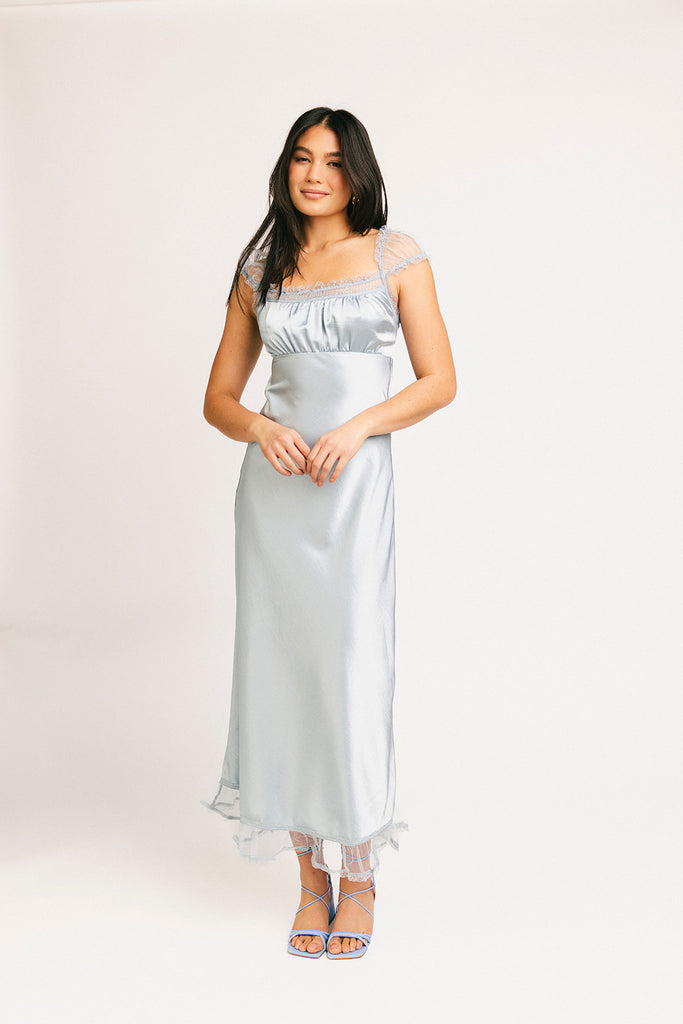 a light blue silk midi dress with lace detailing + a fitted silhouette. the perfect short sleeve occasion dress for weddings, bridal showers, + dinner parties.