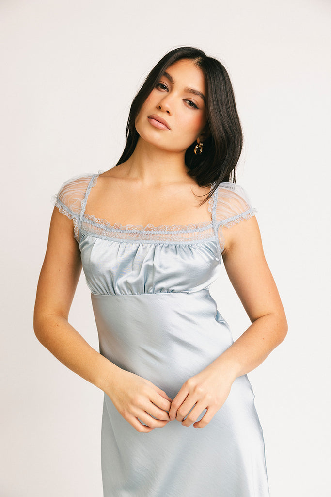 a light blue silk midi dress with lace detailing + a fitted silhouette. the perfect short sleeve occasion dress for weddings, bridal showers, + dinner parties.
