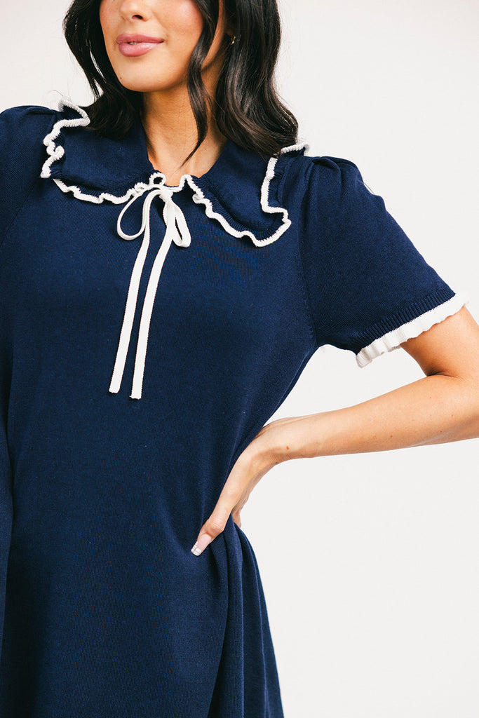a short sleeve knit mini dress with a ruffled collar + bow detail. the perfect navy knit dress for date nights, family pictures, + everyday wear.
