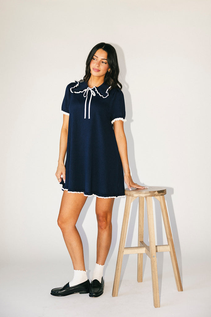 a short sleeve knit mini dress with a ruffled collar + bow detail. the perfect navy knit dress for date nights, family pictures, + everyday wear.