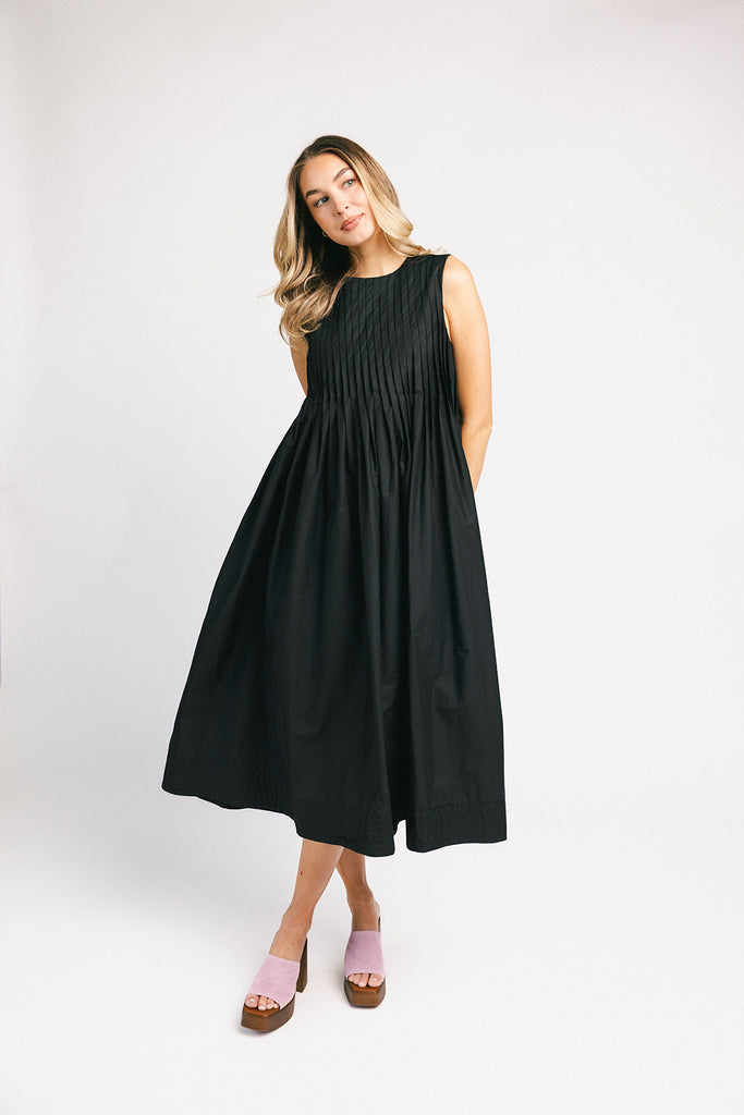 a sleeveless black midi dress with pleated details. the perfect cotton tank dress for weddings, baby showers, brunch dates, + casual outings.