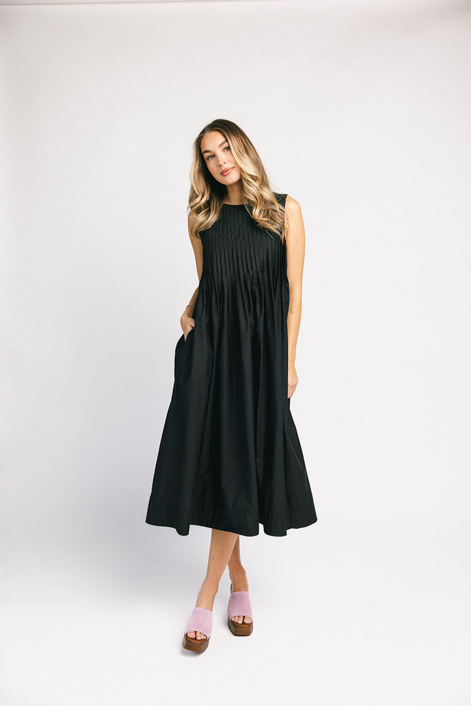 a sleeveless black midi dress with pleated details. the perfect cotton tank dress for weddings, baby showers, brunch dates, + casual outings.