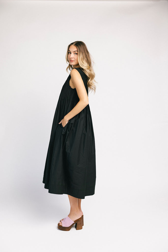 a sleeveless black midi dress with pleated details. the perfect cotton tank dress for weddings, baby showers, brunch dates, + casual outings.