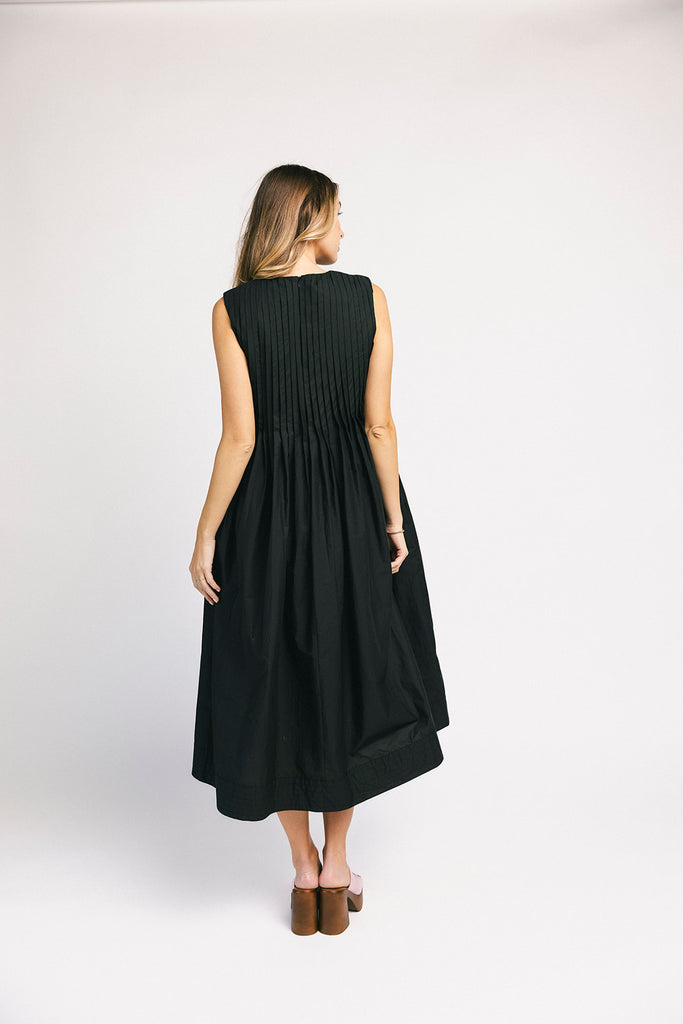 a sleeveless black midi dress with pleated details. the perfect cotton tank dress for weddings, baby showers, brunch dates, + casual outings.
