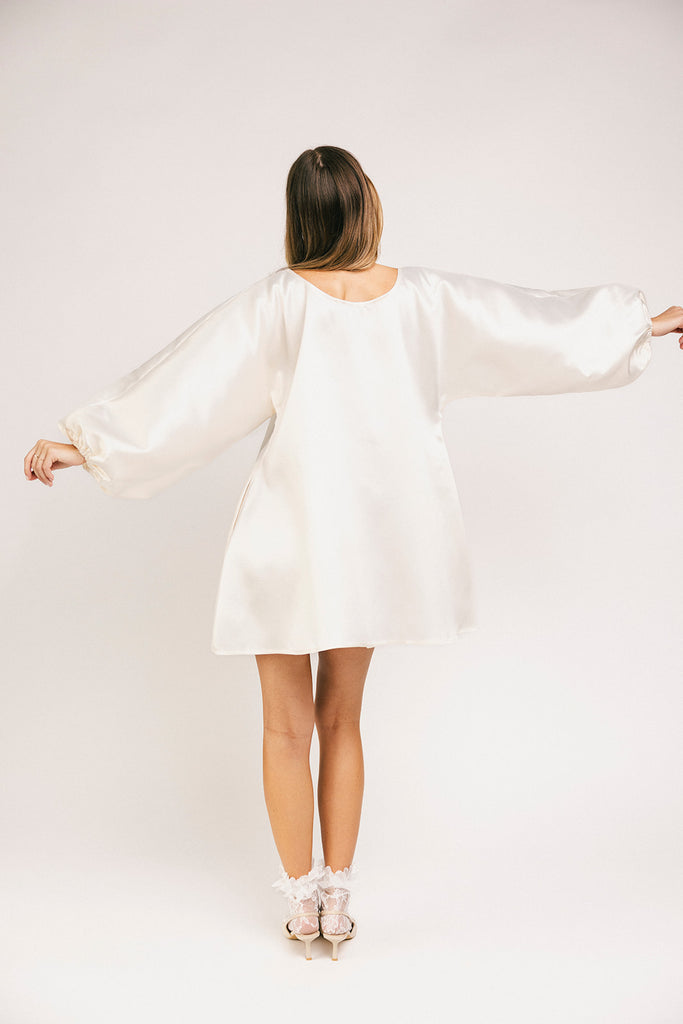 a white satin mini dress with a vintage-inspired silhouette + long balloon sleeves. the perfect little white dress for graduations, bridal showers, + fancy dinner dates.