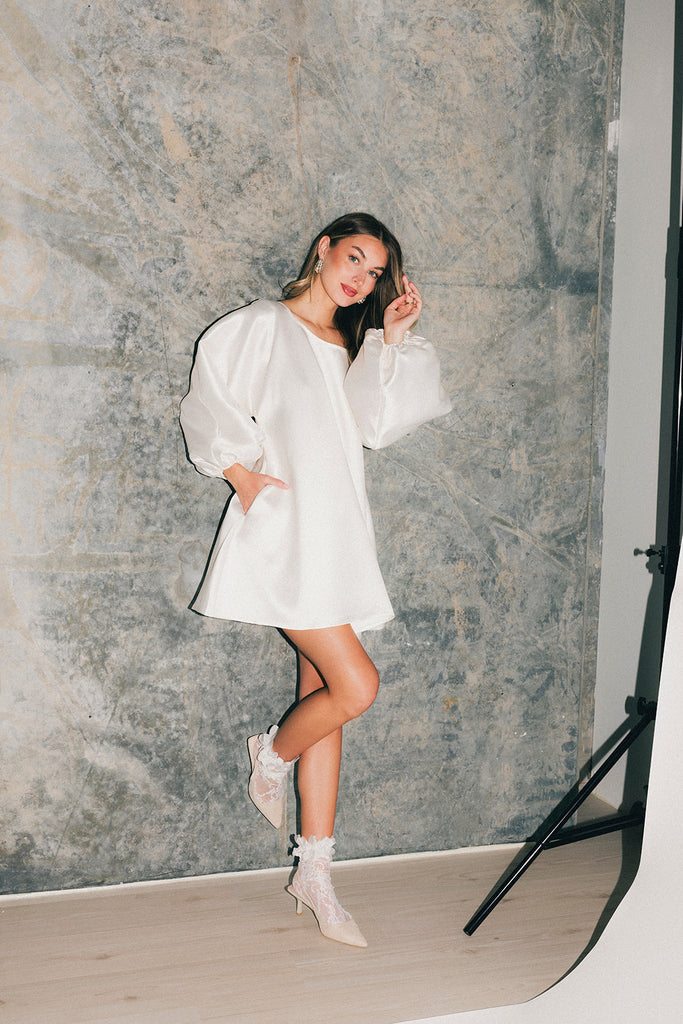 a white satin mini dress with a vintage-inspired silhouette + long balloon sleeves. the perfect little white dress for graduations, bridal showers, + fancy dinner dates.