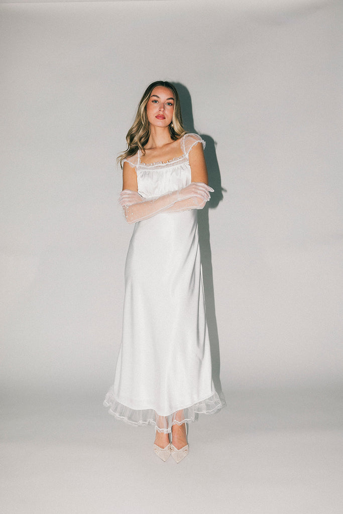 a white satin midi dress with lace detailing + a fitted silhouette. the perfect short sleeve occasion dress for weddings, bridal showers, + dinner parties.
