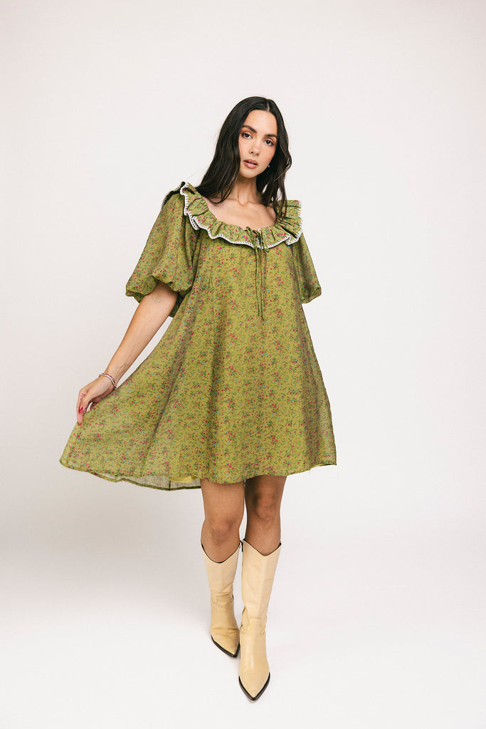 a green floral puff sleeve mini dress with a ruffle neckline. the perfect vintage-inspired dress for baby showers, family pictures, + special occasions.