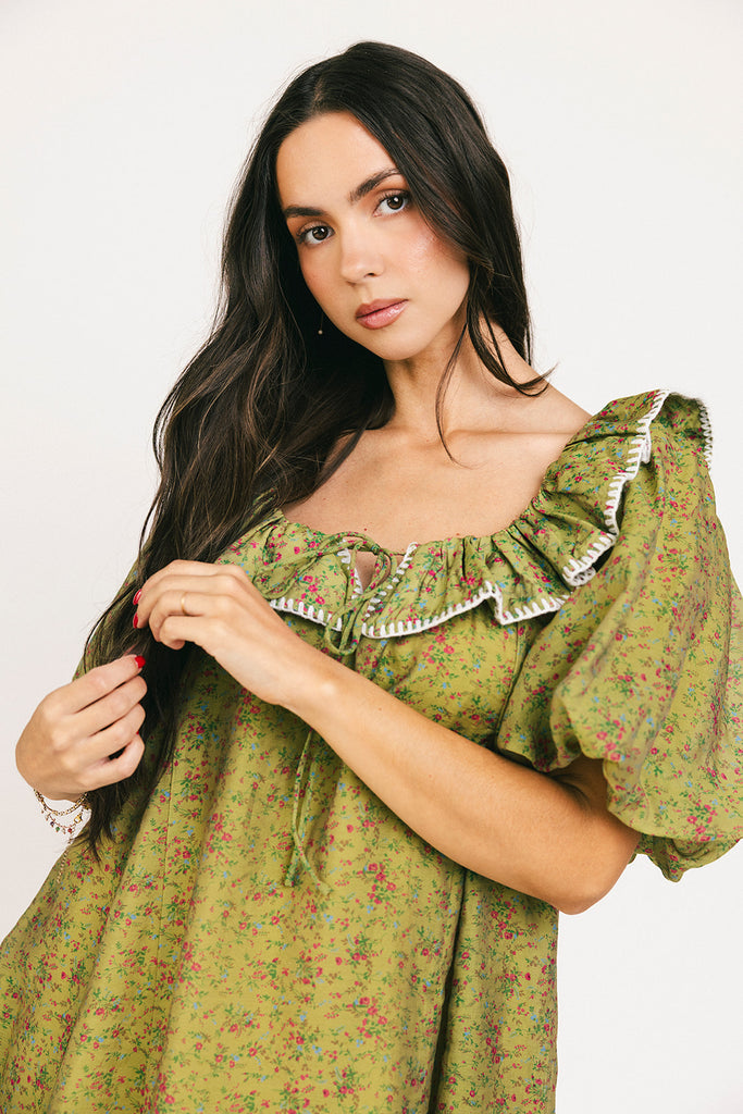 a green floral puff sleeve mini dress with a ruffle neckline. the perfect vintage-inspired dress for baby showers, family pictures, + special occasions.