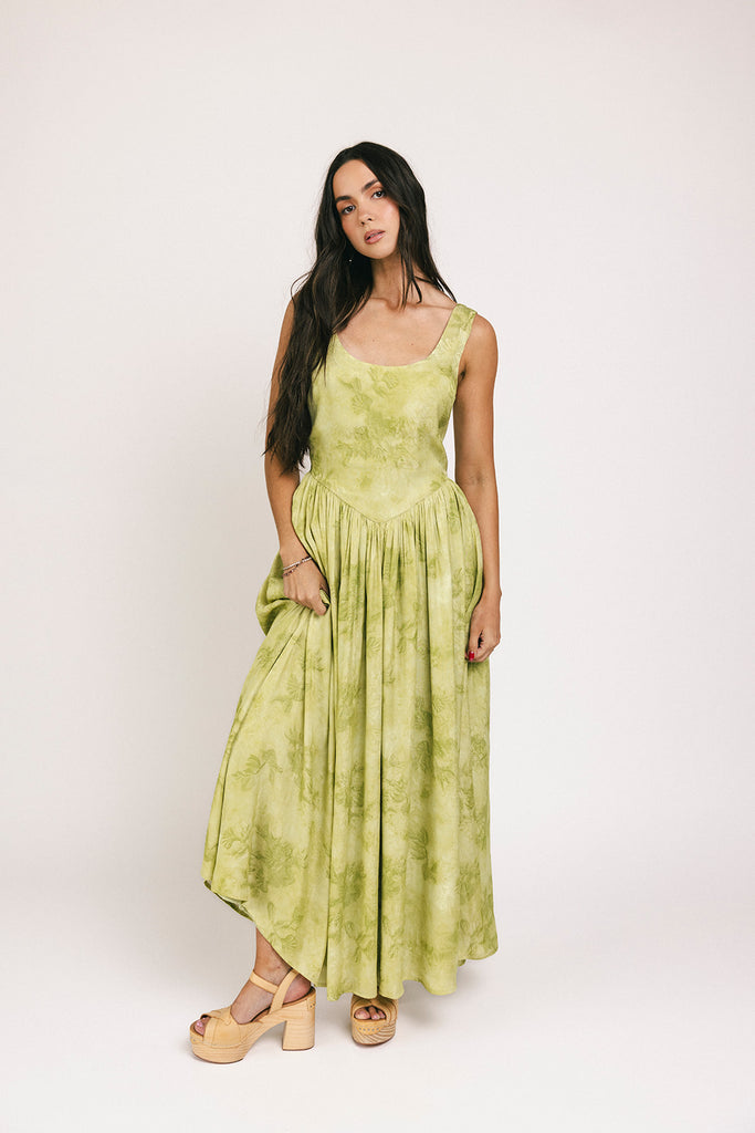 a flowy v-waist green dress with a sleek scoop neckline + subtle floral print. the perfect vintage-inspired maxi dress for weddings, bridal showers, + garden parties.
