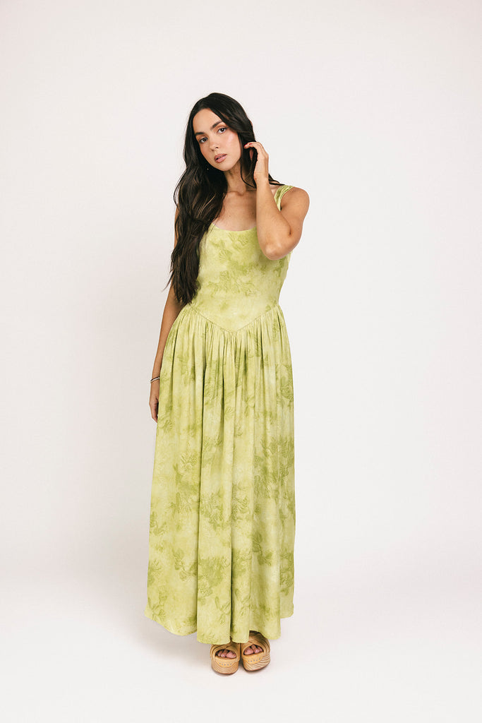 a flowy v-waist green dress with a sleek scoop neckline + subtle floral print. the perfect vintage-inspired maxi dress for weddings, bridal showers, + garden parties.