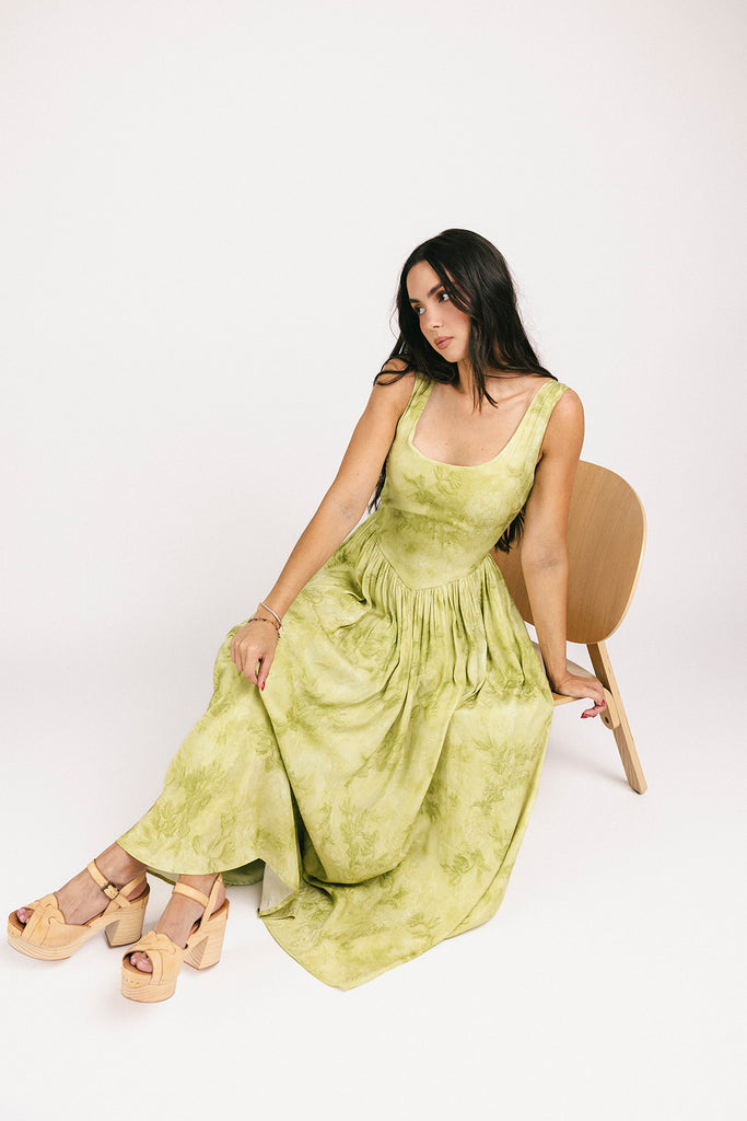a flowy v-waist green dress with a sleek scoop neckline + subtle floral print. the perfect vintage-inspired maxi dress for weddings, bridal showers, + garden parties.
