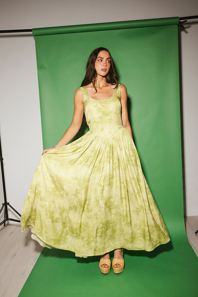 a flowy v-waist green dress with a sleek scoop neckline + subtle floral print. the perfect vintage-inspired maxi dress for weddings, bridal showers, + garden parties.