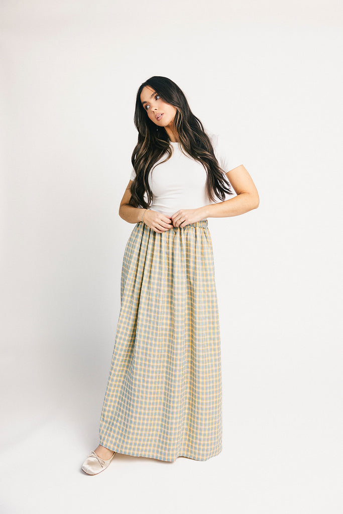 blue and yellow gingham maxi skirt with an elastic waist + side slit details. the perfect flowy gingham skirt to dress up or down for any outfit idea.