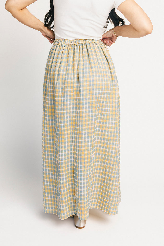 blue and yellow gingham maxi skirt with an elastic waist + side slit details. the perfect flowy gingham skirt to dress up or down for any outfit idea.