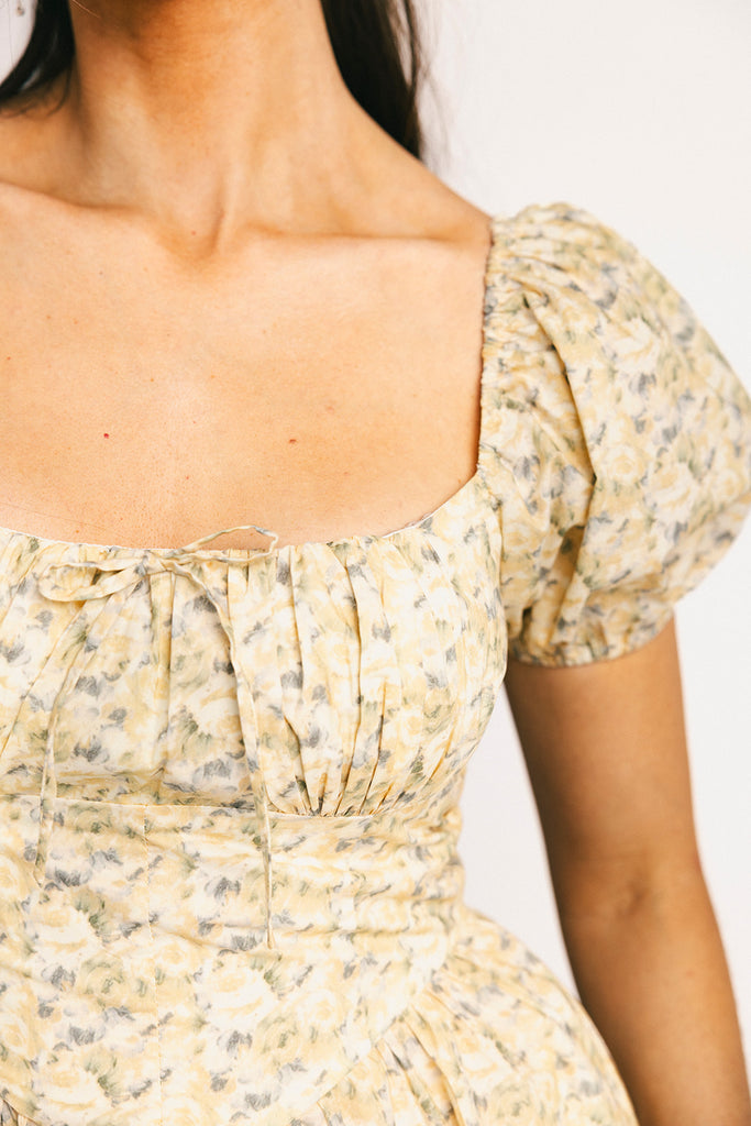 vintage-inspired puff sleeve dress with a muted yellow floral pattern. the perfect puff sleeve midi dress for weddings, bridal showers, + semi-formal events.