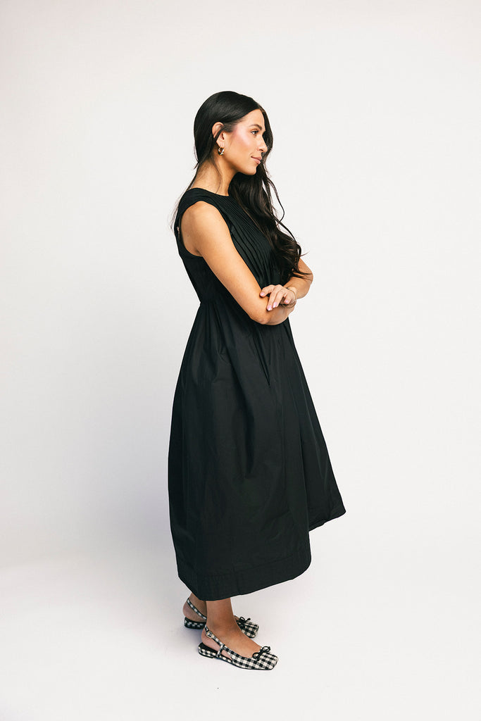 a sleeveless black midi dress with pleated details. the perfect cotton tank dress for weddings, baby showers, brunch dates, + casual outings.