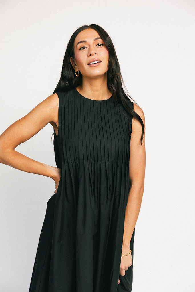 a sleeveless black midi dress with pleated details. the perfect cotton tank dress for weddings, baby showers, brunch dates, + casual outings.