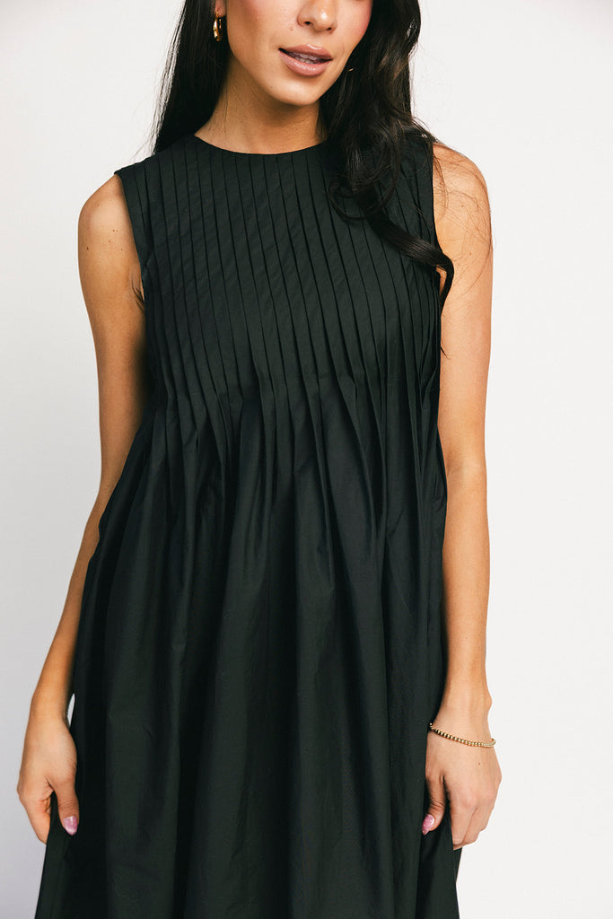 a sleeveless black midi dress with pleated details. the perfect cotton tank dress for weddings, baby showers, brunch dates, + casual outings.