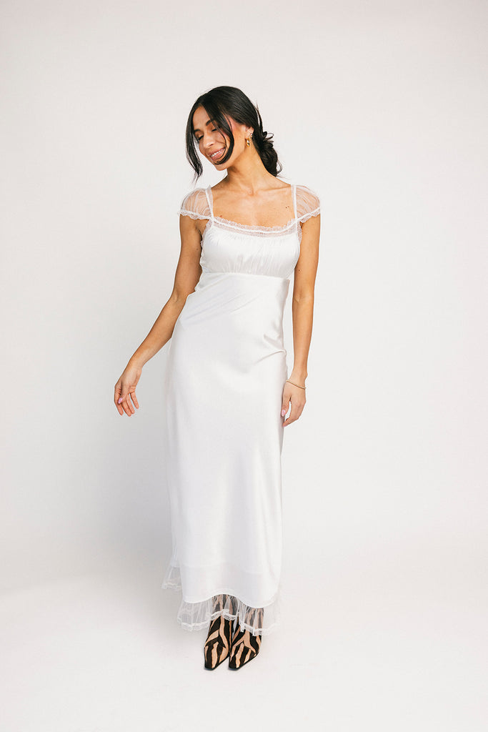 a white satin midi dress with lace detailing + a fitted silhouette. the perfect short sleeve occasion dress for weddings, bridal showers, + dinner parties.