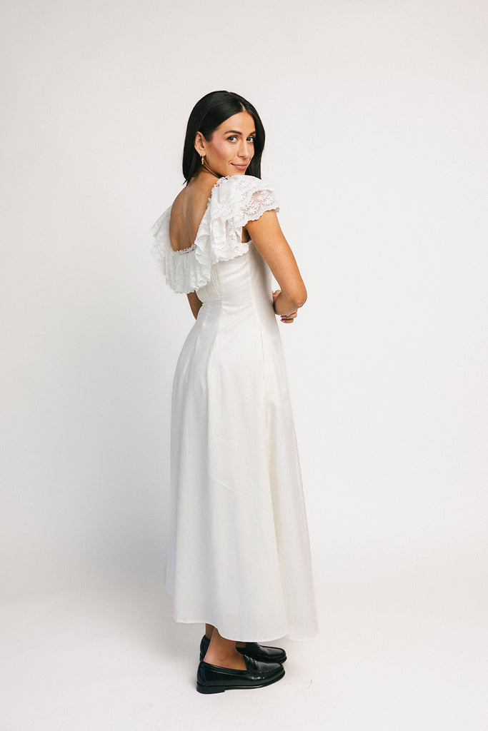 a white vintage-inspired midi dress with a lace ruffle neckline + bow detail. the perfect white dress for bridal showers, rehearsal dinners, + any special occasion.