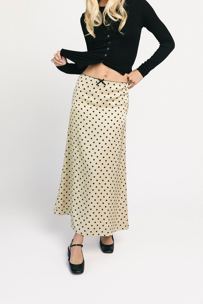 a vintage-inspired polka dot skirt with a dainty bow detail. the perfect slip skirt to dress up or down for any occasion.