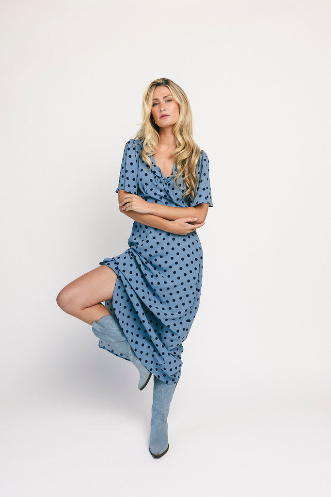 a blue polka dot maxi dress with flutter sleeves + a front tie detail. the perfect short sleeve polka dot dress for brunch dates, baby showers, + semi-formal occasions.