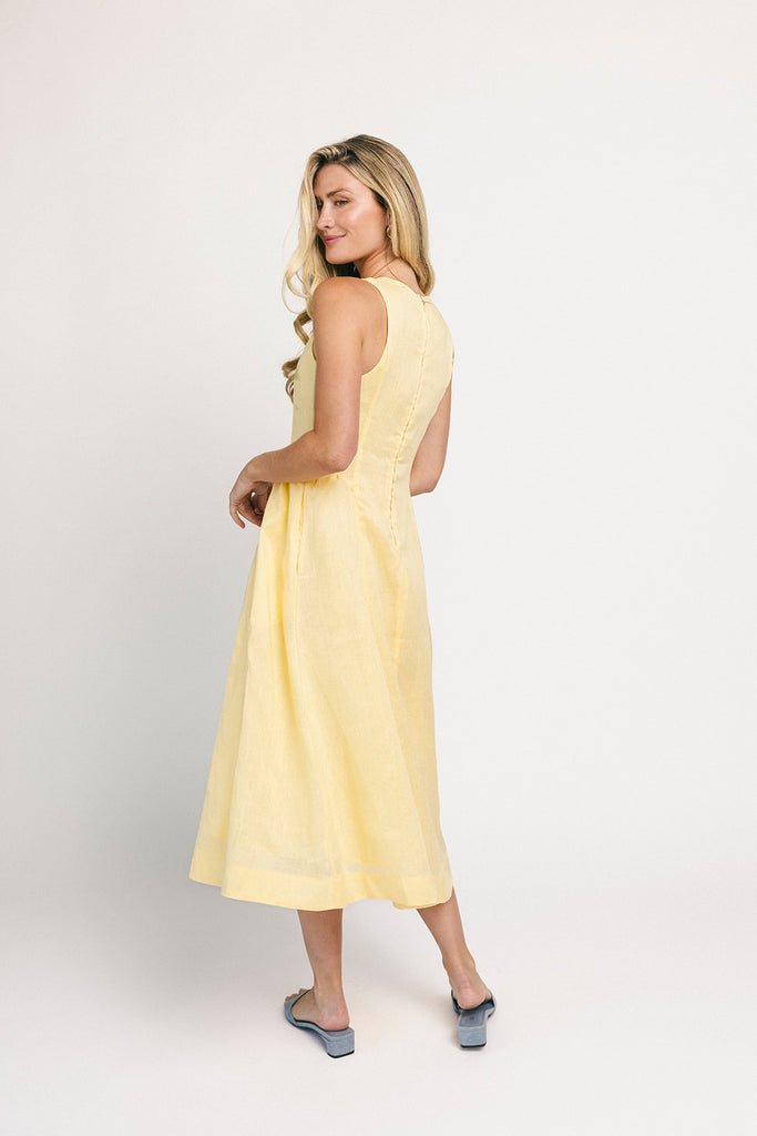 a classic yellow midi dress with a fitted bodice + a v waistline. the perfect vintage-inspired yellow dress for weddings, bridal showers, + garden parties.