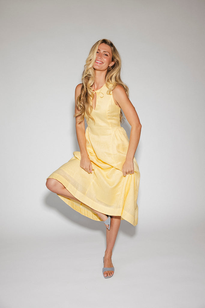 a classic yellow midi dress with a fitted bodice + a v waistline. the perfect vintage-inspired yellow dress for weddings, bridal showers, + garden parties.