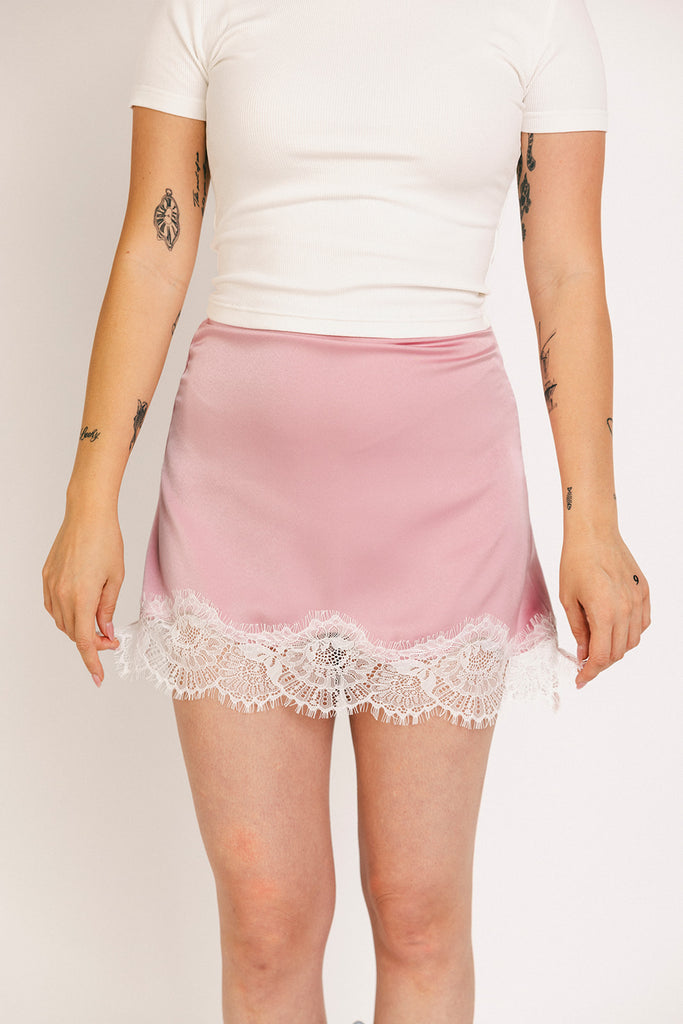 pink satin mini skirt with lace trim. perfect for date night outfits, semi formal outfits, and everyday wear.