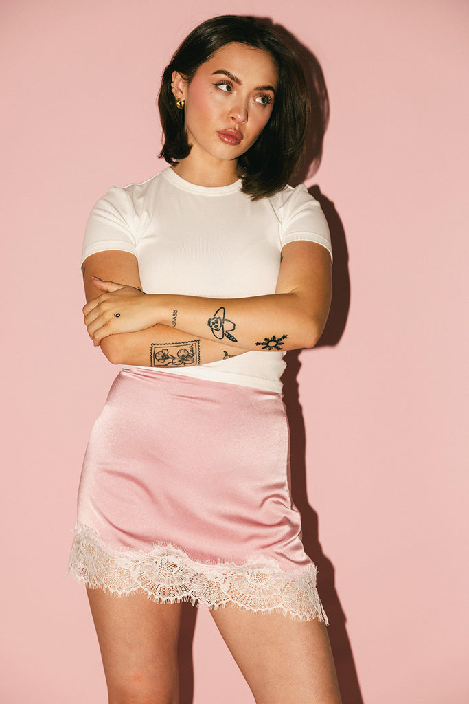 pink satin mini skirt with lace trim. perfect for date night outfits, semi formal outfits, and everyday wear.
