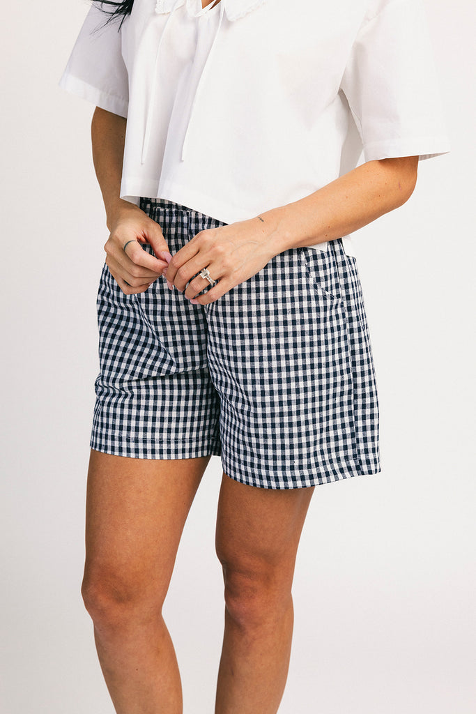 navy blue gingham vintage-inspired shorts with an elastic waist + longline silhouette. the perfect gingham shorts for everyday wear + casual outfit styling.