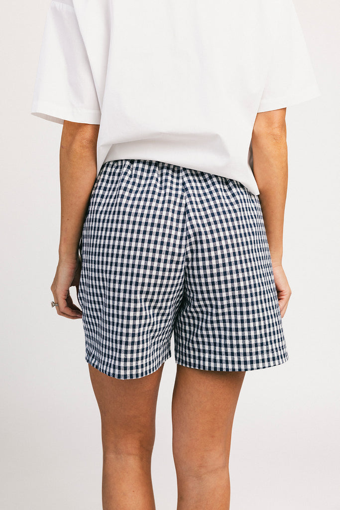 navy blue gingham vintage-inspired shorts with an elastic waist + longline silhouette. the perfect gingham shorts for everyday wear + casual outfit styling.