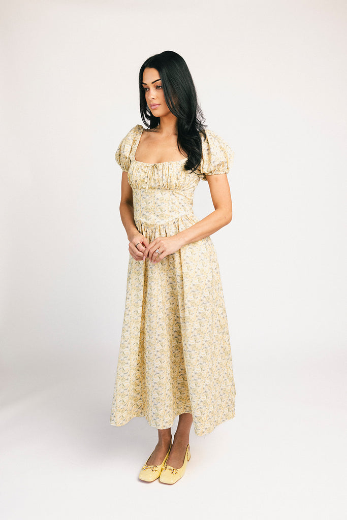 vintage-inspired puff sleeve dress with a muted yellow floral pattern. the perfect puff sleeve midi dress for weddings, bridal showers, + semi-formal events.
