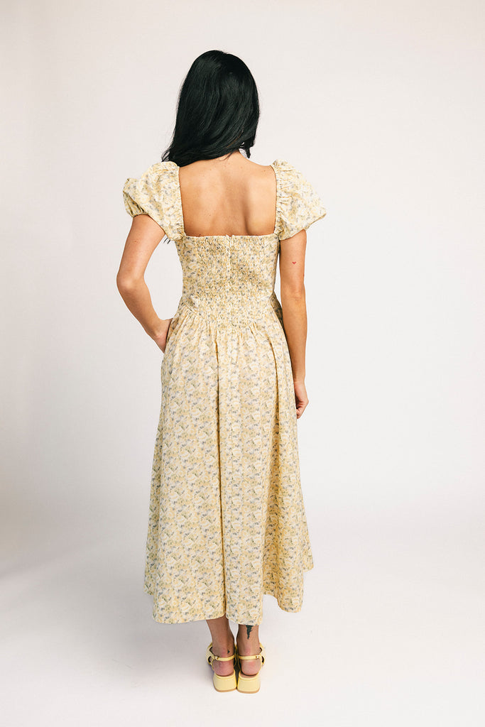 vintage-inspired puff sleeve dress with a muted yellow floral pattern. the perfect puff sleeve midi dress for weddings, bridal showers, + semi-formal events.