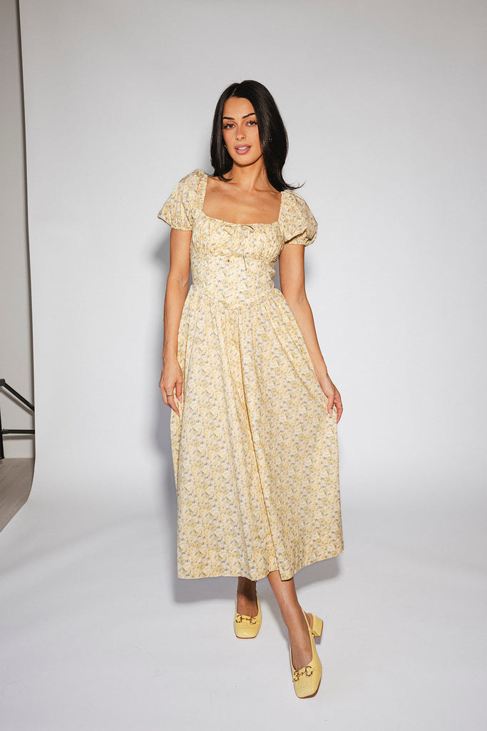 vintage-inspired puff sleeve dress with a muted yellow floral pattern. the perfect puff sleeve midi dress for weddings, bridal showers, + semi-formal events.