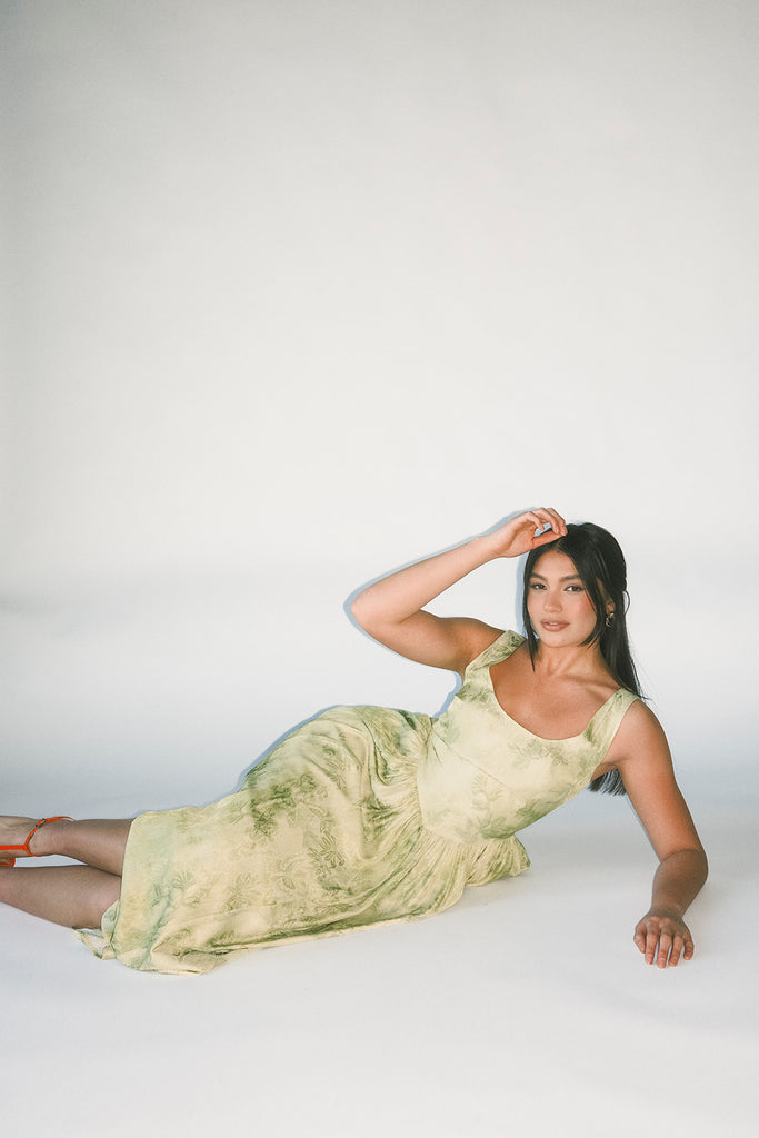 a flowy v-waist green dress with a sleek scoop neckline + subtle floral print. the perfect vintage-inspired maxi dress for weddings, bridal showers, + garden parties.