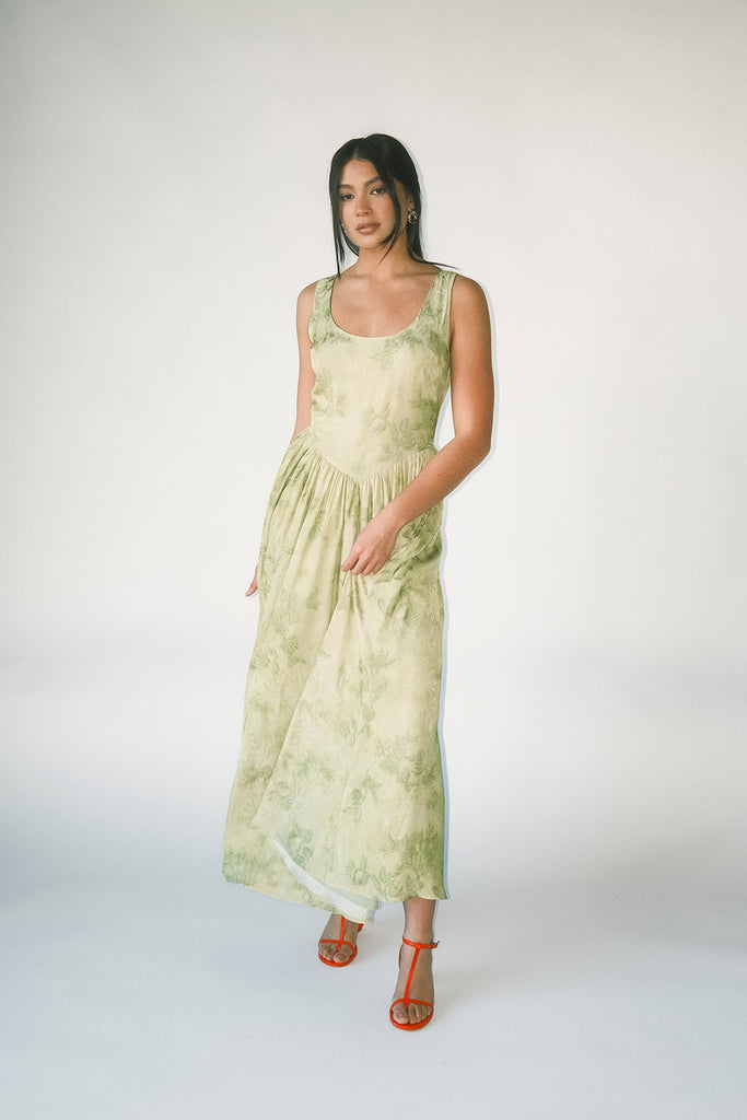 a flowy v-waist green dress with a sleek scoop neckline + subtle floral print. the perfect vintage-inspired maxi dress for weddings, bridal showers, + garden parties.