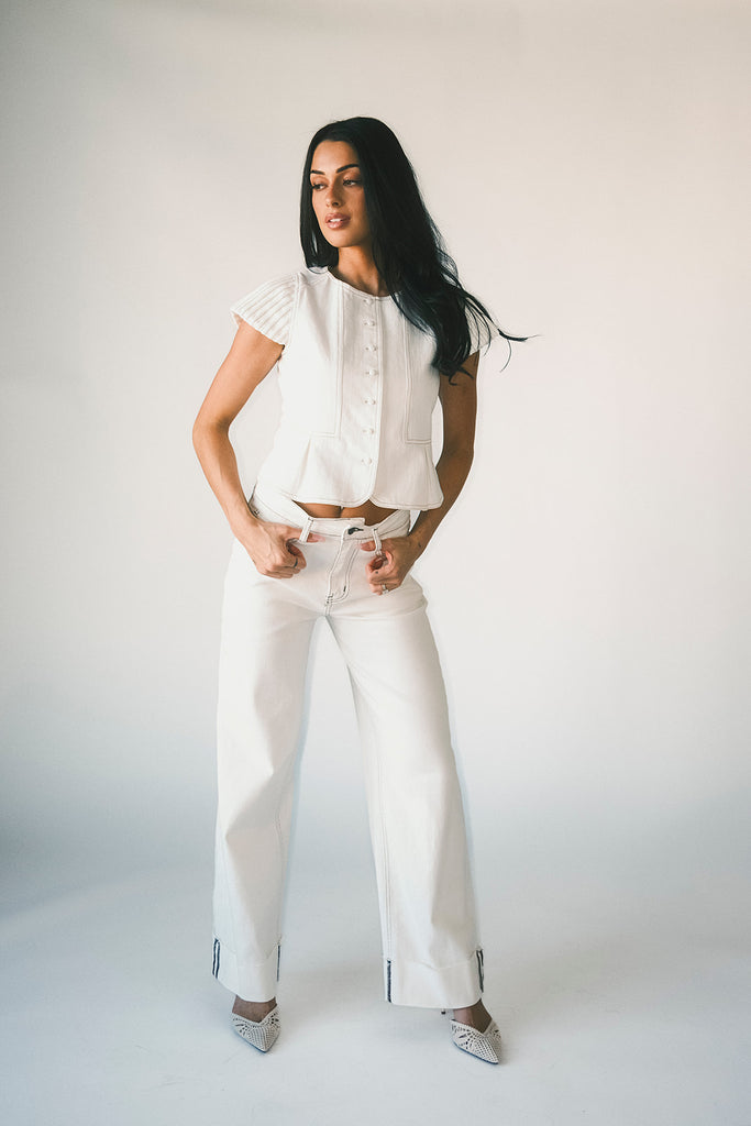 a white denim short sleeve top with a fitted silhouette + a peplum hemline. the perfect denim top to dress up or down for any outfit idea.