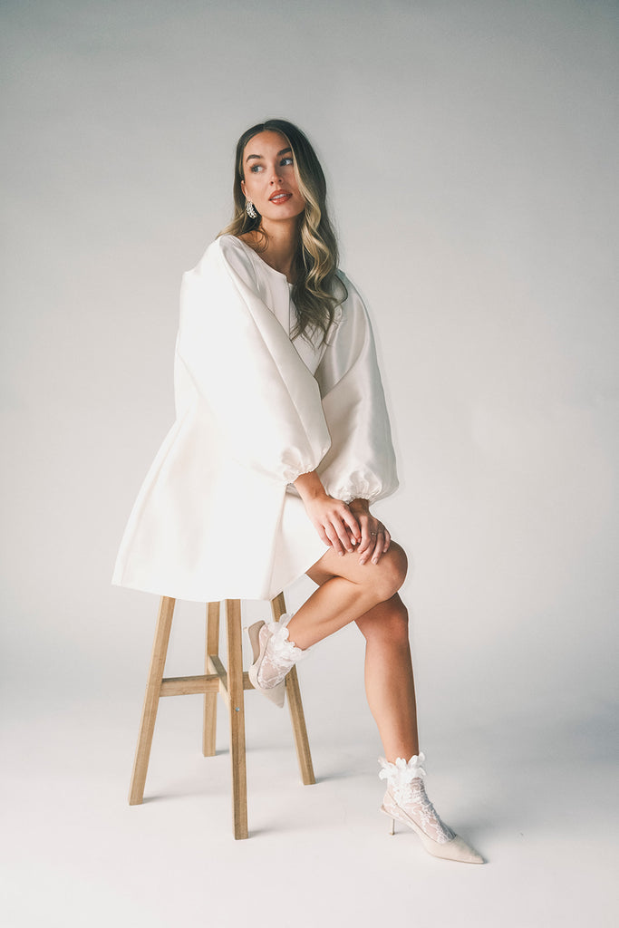 a white satin mini dress with a vintage-inspired silhouette + long balloon sleeves. the perfect little white dress for graduations, bridal showers, + fancy dinner dates.