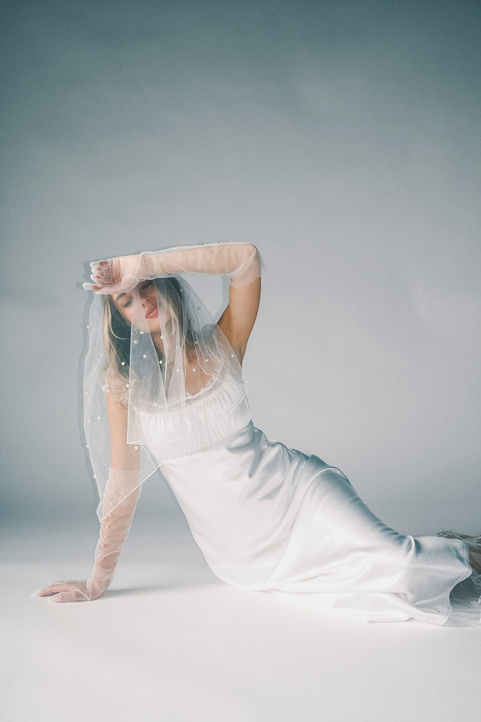 a white satin midi dress with lace detailing + a fitted silhouette. the perfect short sleeve occasion dress for weddings, bridal showers, + dinner parties.